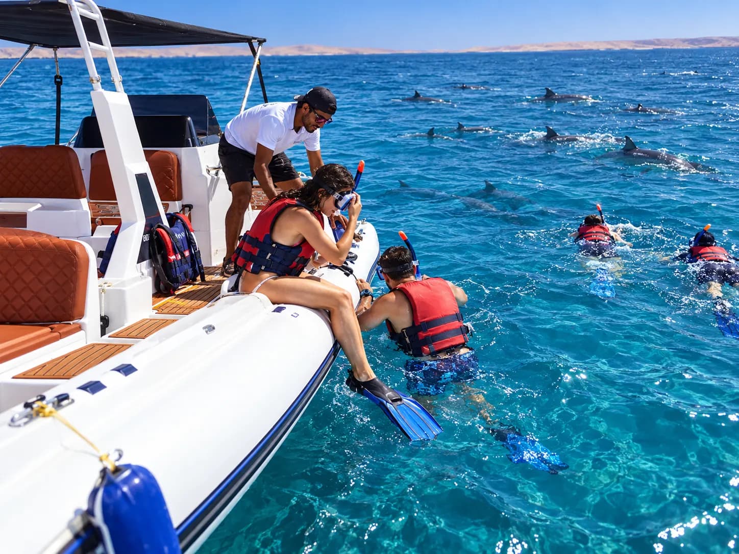 Guide hilft einem Gast vom Schnellboot ins Wasser